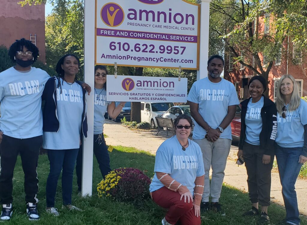 people gathered in front of Amnion sign
